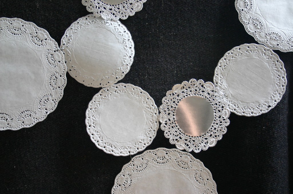 Staple edges together to create a design of your liking and attach to your tablecloth with doublesided tape. Doilies can be purchased at craft and party stores.