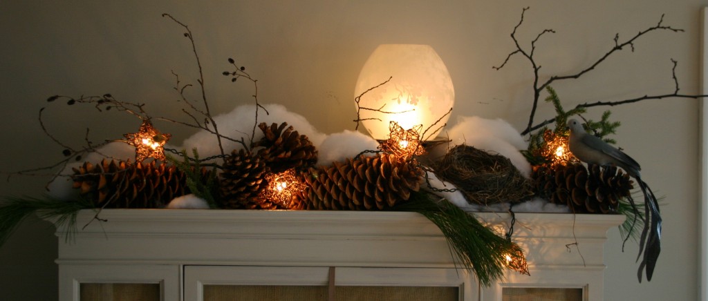 Using large sugar cones, branches, a strand of wicker star lights and a glass globe light from Ikea, I created a winter still life on top.