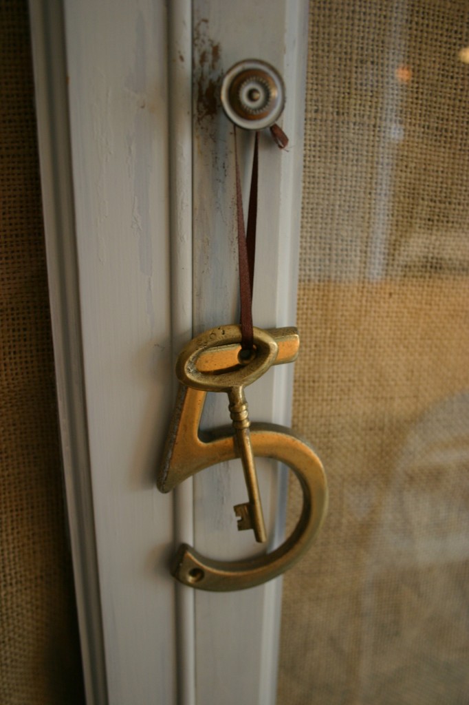 An old brass house key and a house number hang from the knob to add interest and sparkle. My younger daughter just turned 5 - so she loves this detail.