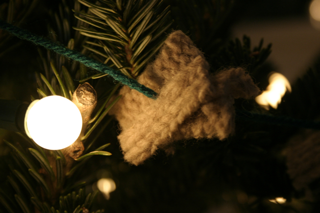 Bits of an old sweater are clipped into small squares and strung on yarn to make a soft, textured garland.