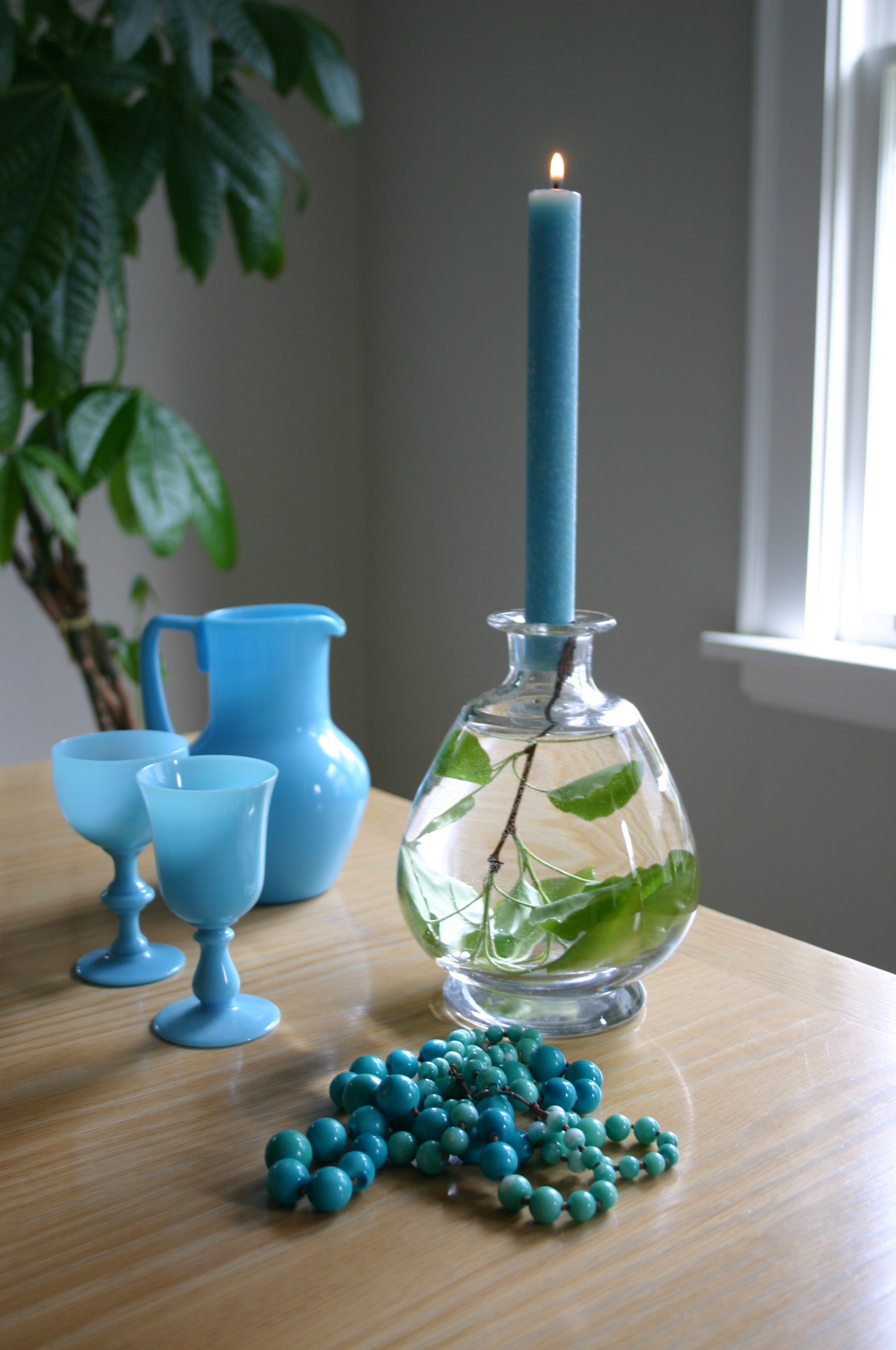 IMG_9915 I love to have something interesting on the table when I entertain. I filled a crystal decanter with water, placed a clipping from our pear tree inside and stuck a candle into the opening.