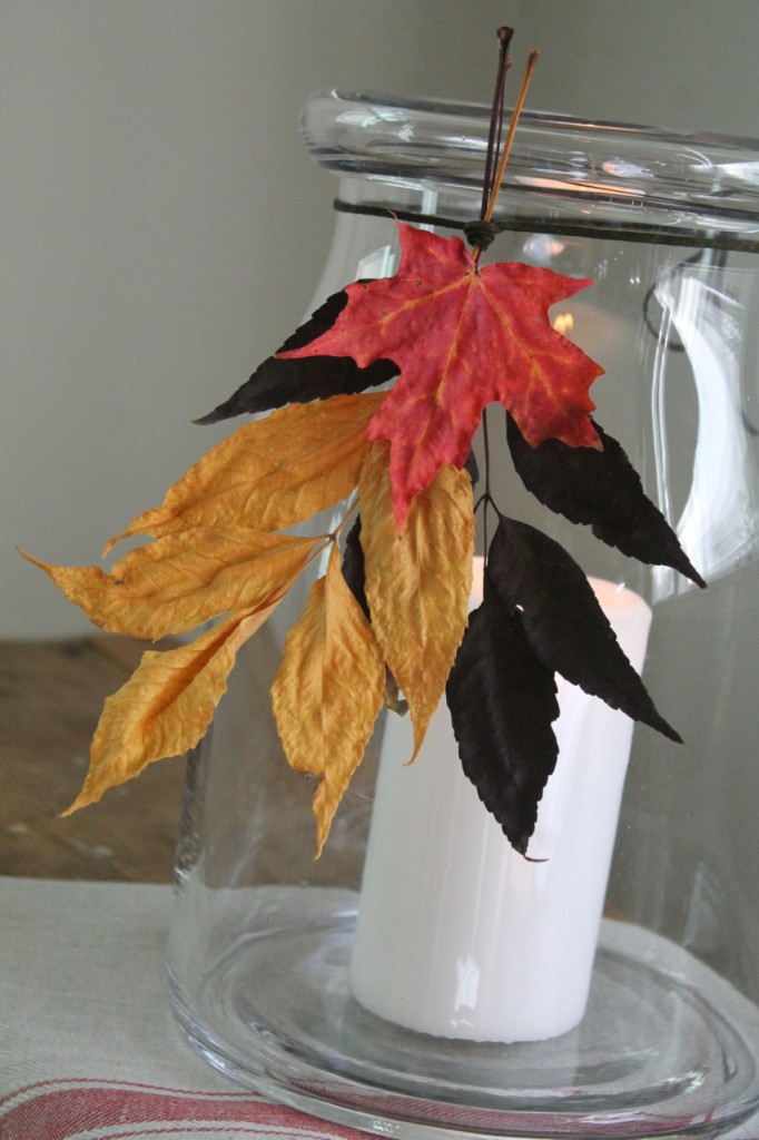 Collect leaves from outdoors. Press in a book for a few days. This will help to preserve the leaf. Arrange leaves in a bundler, tie together with a leather cord, tie around mouth of large jar.